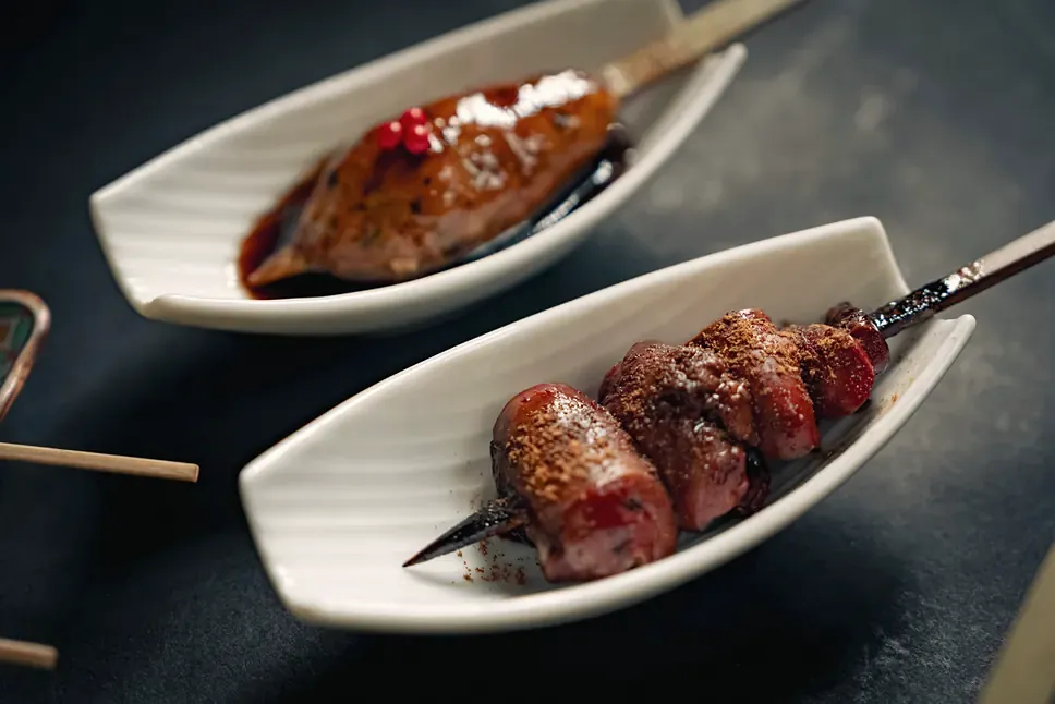 Skewers in boat-shaped dishes at Yakitori Suzune