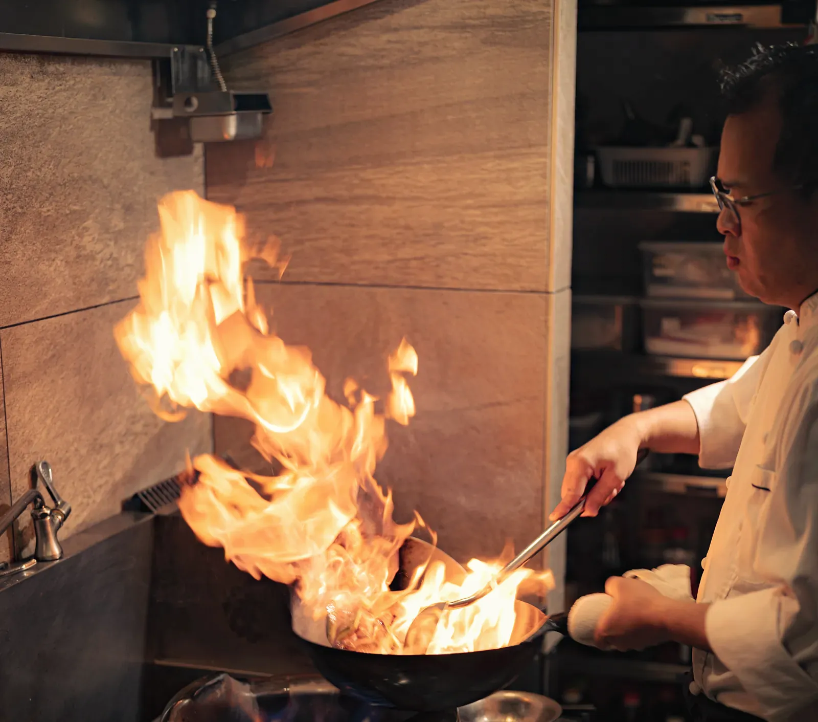 웍에서 불꽃을 일으키는 Yakitori Suzune의 주인장