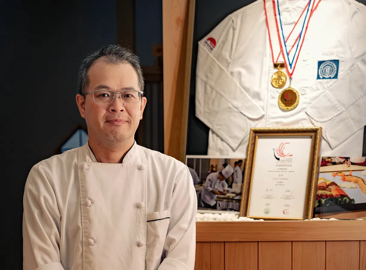 The owner-chef of Yakitori Suzune beside his framed medals